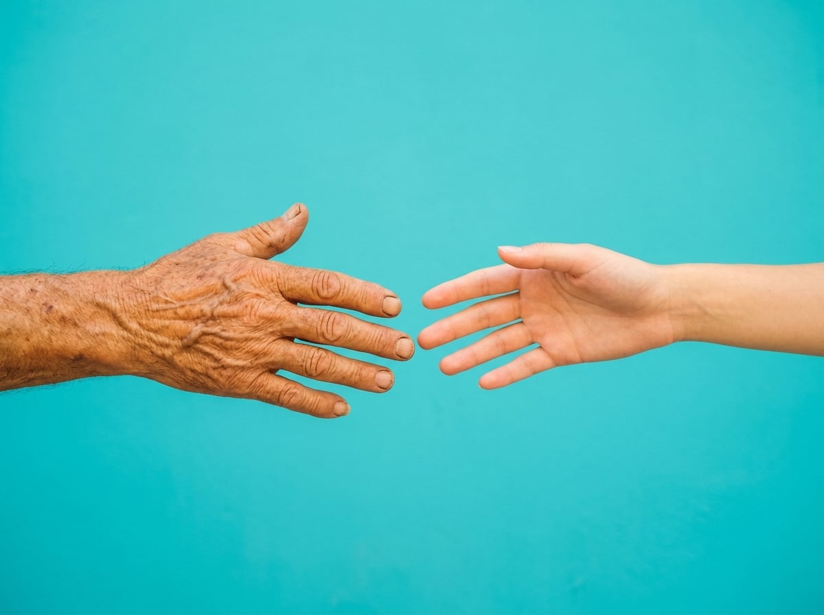 Two hands reaching, fingertips not quite touching